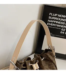 Detail of adjustable beige strap and drawstring closure on leopard print bucket bag