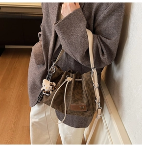 Detail of leopard print bucket bag with drawstring closure and cute character charm
