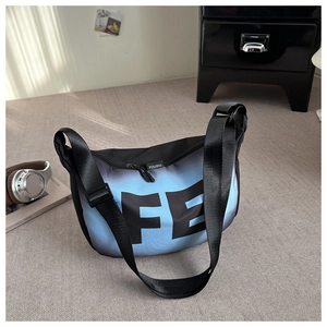Détail du sac croissant dégradé bleu avec logo FE et bandoulière en nylon réglable