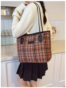Detail of vintage plaid tote bag with plush fabric and black shoulder strap for commuting