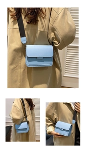 Detail of light blue crossbody bag with thick black strap and matte leather finish