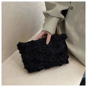 Detail of 3D mesh rose petals on a black evening clutch bag with romantic floral texture