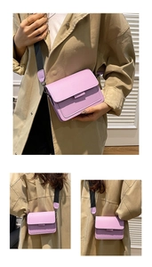 Detail view of purple crossbody square bag with wide two-tone strap on beige trench coat