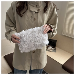 Detailed close-up of white 3D mesh rose textures on a stylish floral evening clutch bag