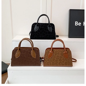 Detailed view of leopard print handbags in black, dark brown, and light brown colors