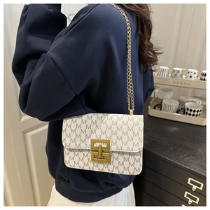 Lifestyle shot of white crossbody bag with grey M pattern and gold chain strap