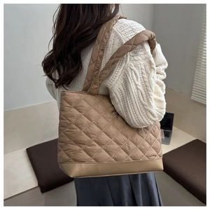 Detail of khaki quilted tote bag shown with an elegant autumn outfit and casual style