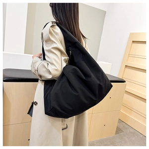 Detail einer großen schwarzen Nylon-Tragetasche mit Glanzfinish und Reißverschluss
