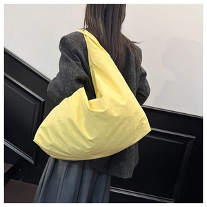 Detailansicht der großen gelben Hobo-Bag mit natürlicher Knitteroptik am Modell