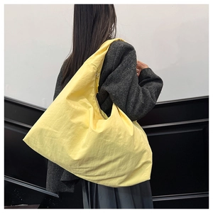 Detail einer leuchtend gelben Tragetasche mit Nylon-Textur an einem Model gezeigt