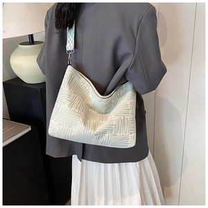 Detail of green striped canvas hobo bag showing woven texture and silver metal clasp