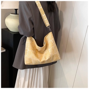 Detail of yellow geometric canvas crossbody bag with wave patterned wide shoulder strap