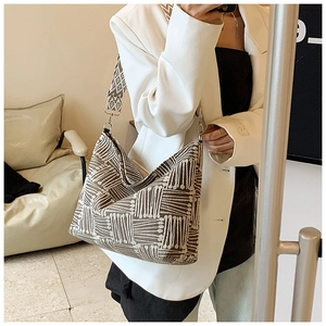 Detailed view of grey and white checkered canvas tote bag with wide shoulder strap