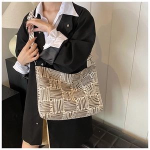 Detail of retro striped knit shoulder bag showing geometric texture and wide jacquard strap