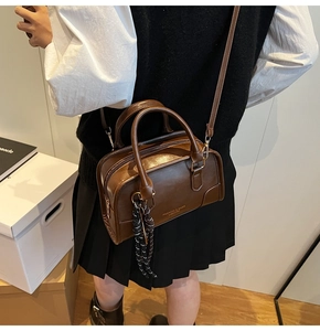 Close-up of brown PU leather Boston bag featuring handle details and decorative tassel