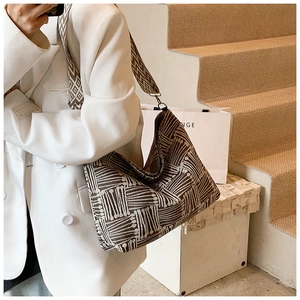 Detail of a large striped canvas tote bag with geometric pattern and wide woven strap