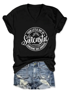 Détail du t-shirt noir à col en V avec texte imprimé et short en jean bleu clair délavé