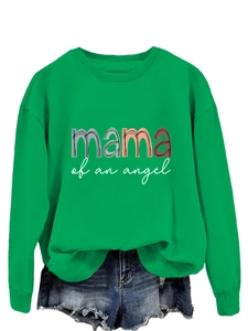 Détail du texte coloré 'mama of an angel' sur un sweat vert à col rond et bords côtelés