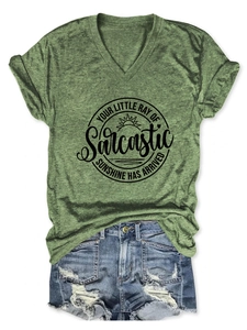 Détail du t-shirt vert avec imprimé Sarcastic Sunshine et short en jean effiloché