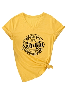 Détail d'un t-shirt jaune à col en V avec nœud à l'ourlet et imprimé graphique noir
