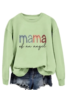 Détail du sweat vert clair avec imprimé Mama of an Angel et short en jean assorti