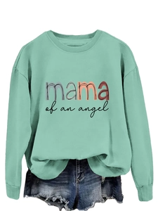 Détail du sweat vert menthe avec motif coloré mama of an angel et un short en jean