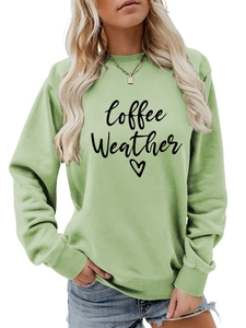 Detail shot of 'Coffee Weather' print on a light green long-sleeved crewneck sweatshirt