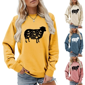 Detail of artistic sheep print with floral patterns on a yellow crewneck sweatshirt