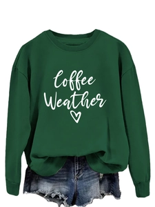 Close-up of Coffee Weather script and heart print on dark green crewneck sweatshirt