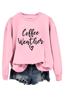 Detail of pink sweatshirt with Coffee Weather print, ribbed cuffs, and frayed denim shorts