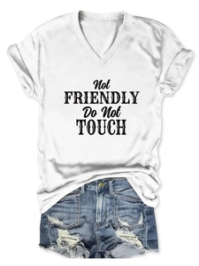 Flat lay of a white V-neck T-shirt with black text and distressed blue denim shorts