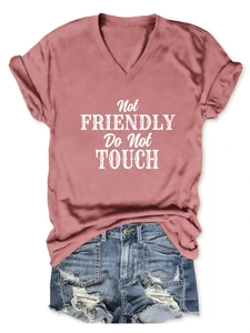 Detail of pink-brown V-neck T-shirt with text and distressed ripped denim shorts
