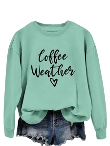 Detail of mint green sweatshirt with Coffee Weather print tucked into denim shorts