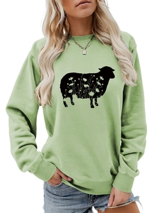 Close-up of sheep silhouette with floral cutout pattern on light green crewneck sweatshirt