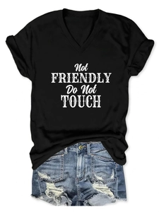 Detail of V-neck cotton T-shirt with Not Friendly slogan print and ripped denim shorts