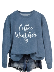 Detailed view of Coffee Weather text and heart print on a blue crewneck sweatshirt