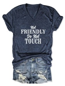 Close-up of V-neck tee with 'Not Friendly' print and distressed denim shorts texture