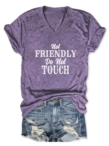 Flat lay of purple V-neck T-shirt with graphic print and distressed denim shorts