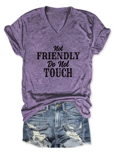 Flat lay of purple V-neck T-shirt with Not Friendly print and distressed denim shorts