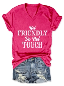 Flat lay of pink V-neck T-shirt with 'Not Friendly' print and ripped denim shorts