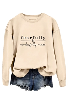 Détail de l'imprimé Fearfully Wonderfully Made sur un sweat-shirt beige clair