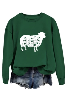 Detail of dark green sweatshirt featuring white sheep print with floral texture patterns