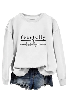 Gros plan sur l'imprimé fearfully wonderfully made sur le sweat-shirt blanc