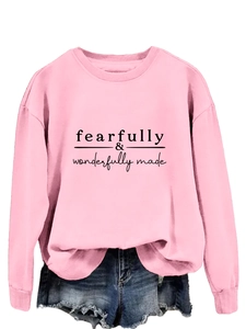 Détail du sweat rose imprimé Fearfully Wonderfully Made et d'un short en jean bleu