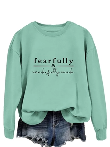 Détail du sweat vert menthe avec inscription noire fearfully wonderfully made en relief