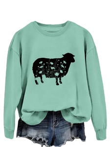 Detail view of mint green sweatshirt featuring a sheep silhouette with floral patterns