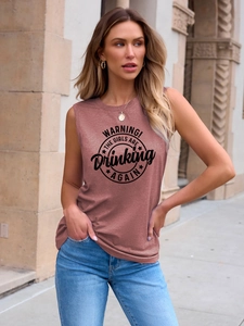 Detail of brick red sleeveless top featuring black circle graphic and slogan print