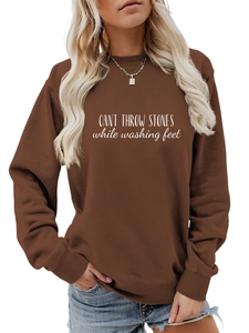 Gros plan de l'imprimé blanc sur un sweat-shirt marron avec col et ourlet côtelés