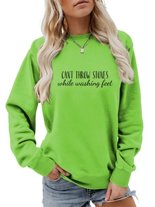 Détail du sweat à col rond vert néon avec texte imprimé noir sur la poitrine