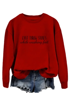 Détail d'un sweat rouge à col rond avec lettrage noir et un short en jean